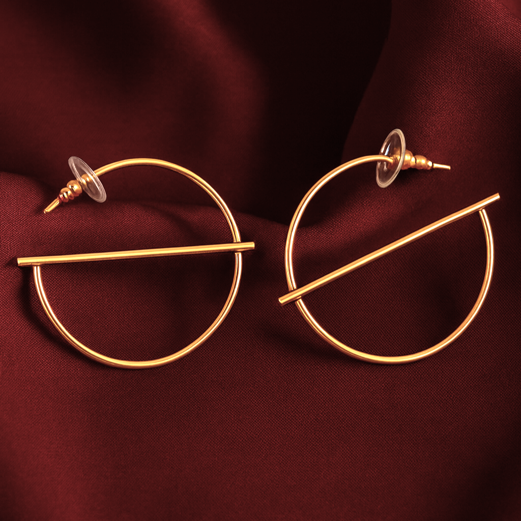 Minimalist gold-plated hoop earrings with a sleek horizontal bar design, Solace earrings by Masaira displayed on maroon satin fabric.