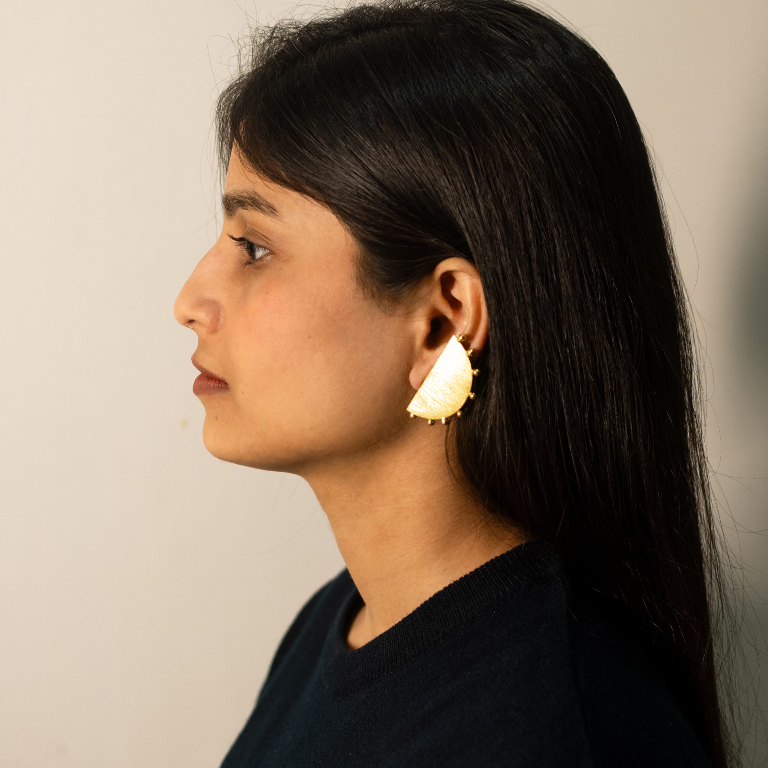 Masaira Eclipse Gold-Plated Half-Moon Beaded Edge Stud Earrings — Right Profile Right profile: model wearing Masaira Eclipse brushed half-moon stud with beaded edge