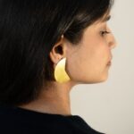 Right profile: Masaira Split Circle gold-plated asymmetrical stud (curved wedge half) with brushed finish
