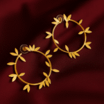 Masaira Laurel gold-plated hoop earrings with laurel leaf accents on deep maroon satin