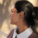 Gold-plated asymmetrical hoop earrings named Solace by Masaira, minimalist modern design captured in natural light.