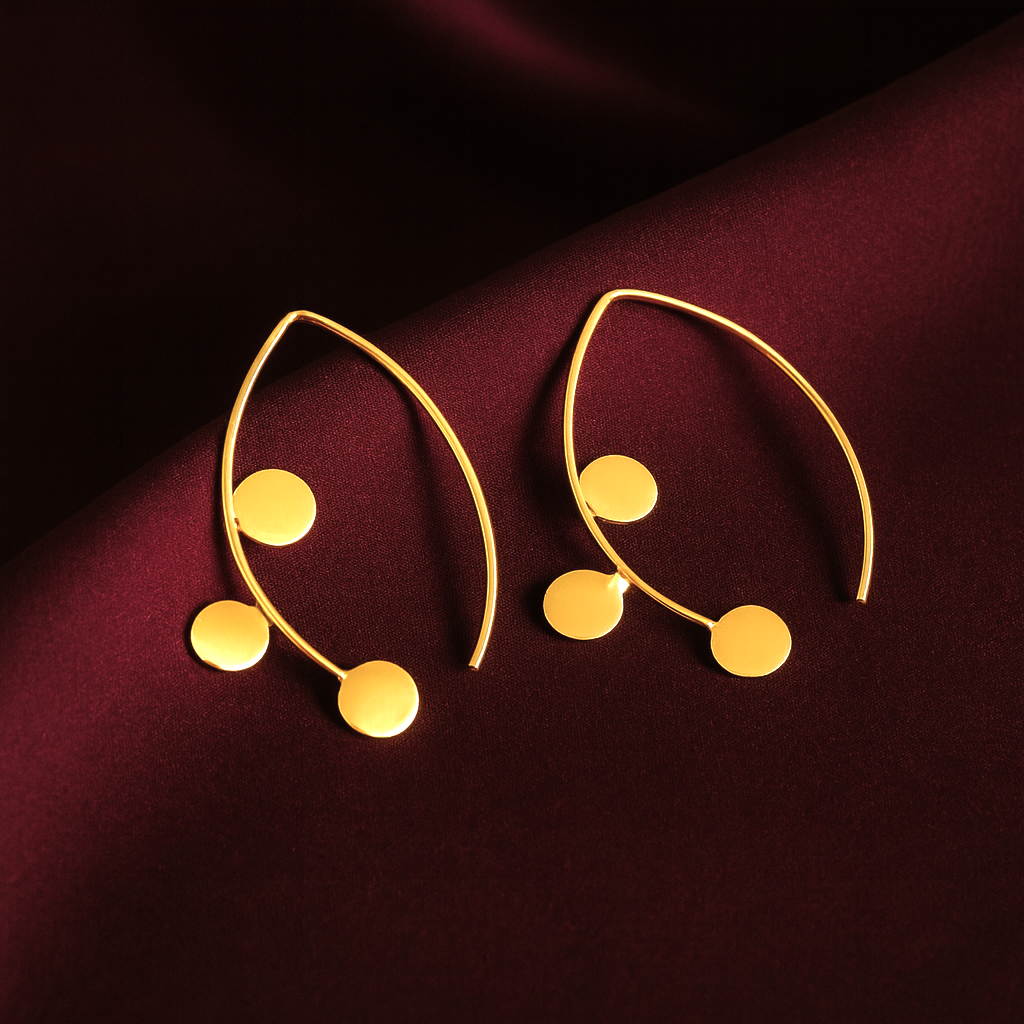 Masaira Myra gold-plated marquise open-frame earrings with three round coin discs on deep maroon satin