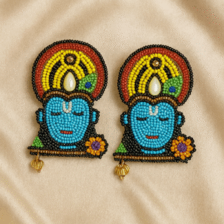 Handcrafted beaded Krishna face earrings with vibrant colors on a satin beige background — Masaira deity-inspired jewellery