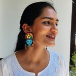 Model in white embroidered kurta smiling while wearing Krishna beaded earrings with temple detailing — Masaira handmade jewellery