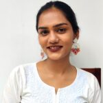Indian woman smiling and wearing Shimmering Arch beaded earrings on both ears