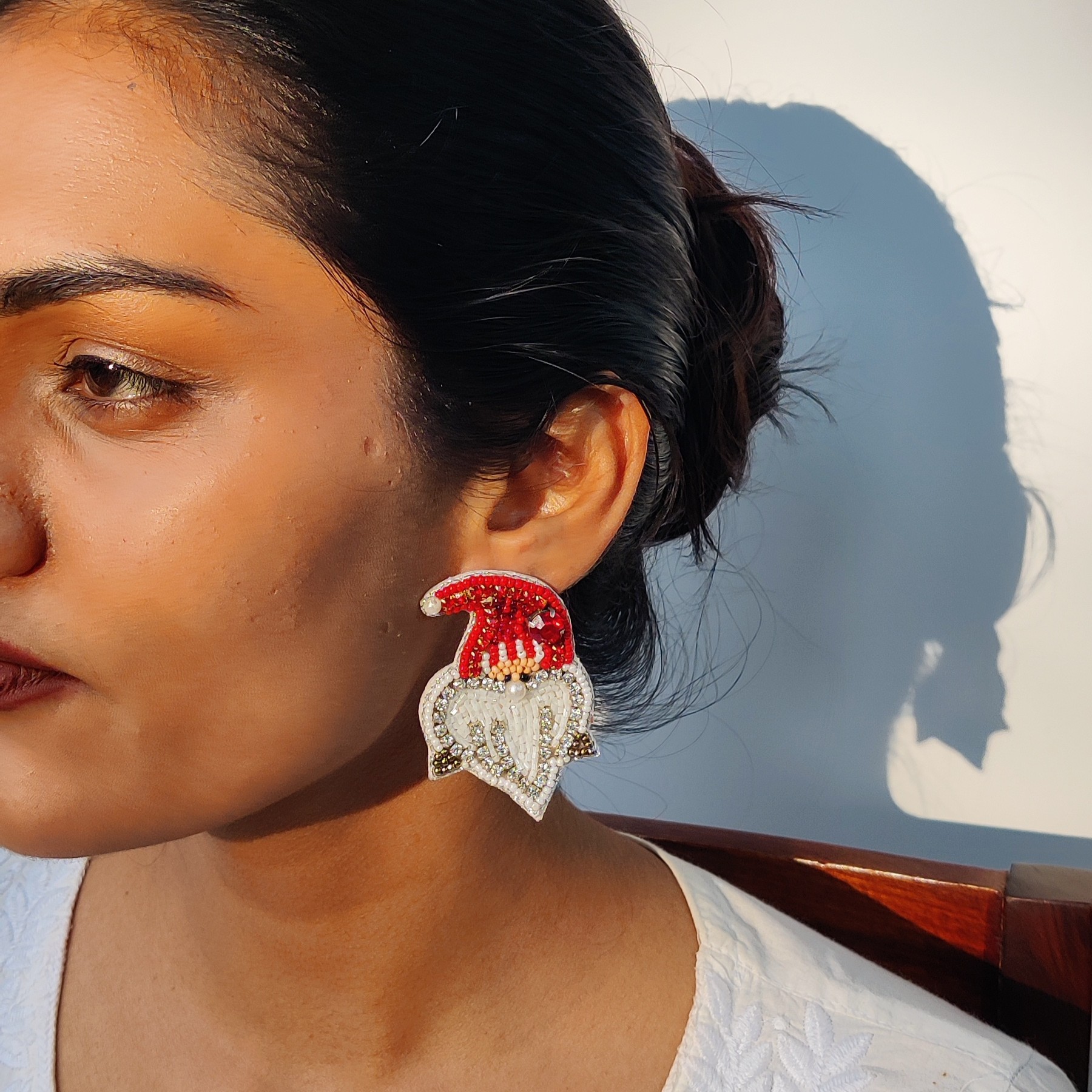 Close-up of a woman wearing a handcrafted beaded Santa hat earring