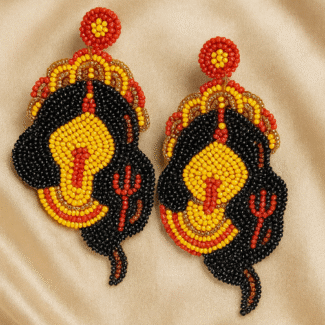 Handcrafted beaded Kali earrings inspired by Hindu Goddess Kali with trident detailing on champagne satin background