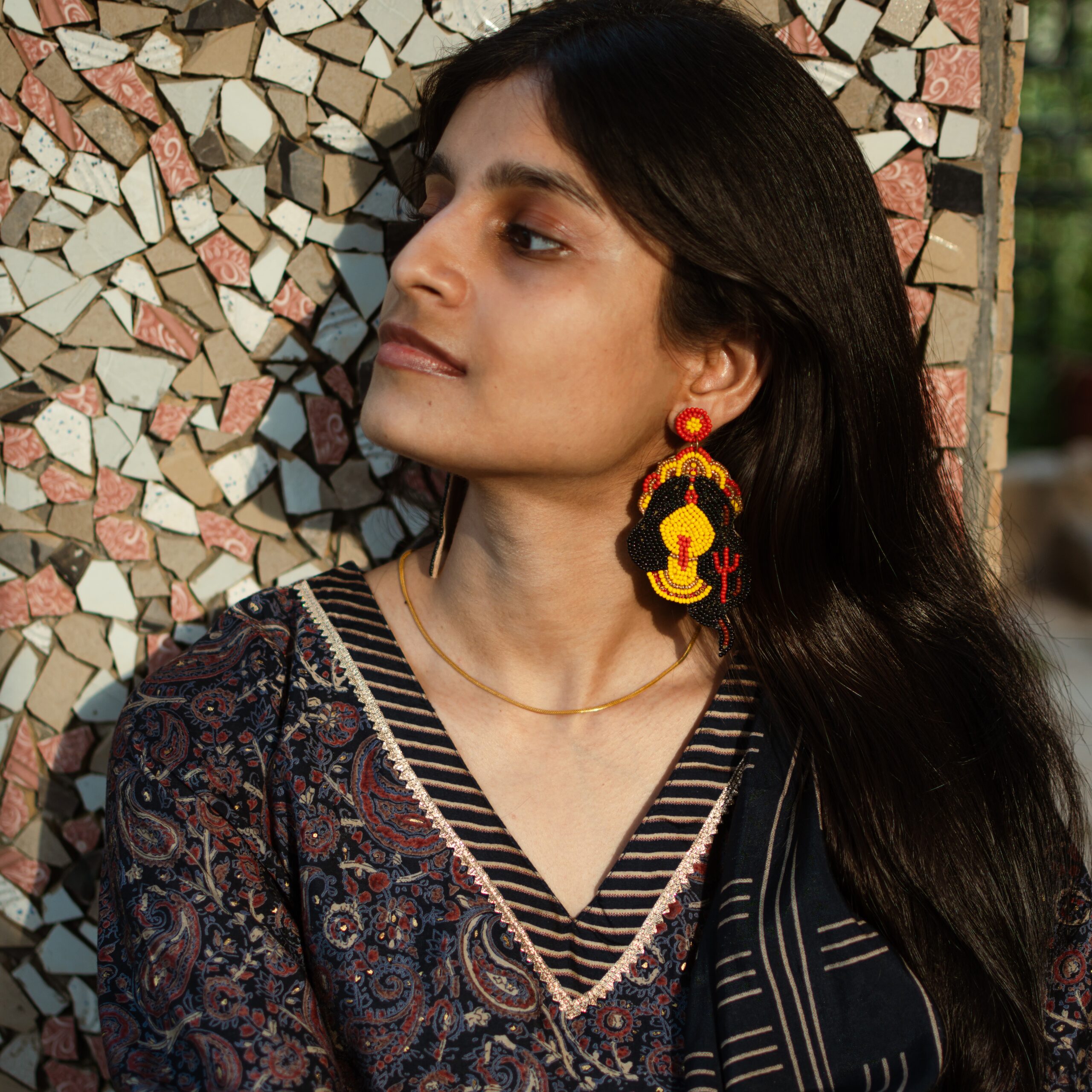 Indian woman wearing beaded Kali earrings inspired by the fierce Hindu Goddess Kali, styled with ethnic attire.