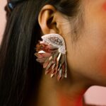 Extreme close-up of Masaira's Celestial Wings earring featuring layered silver beads and wing-inspired design details.