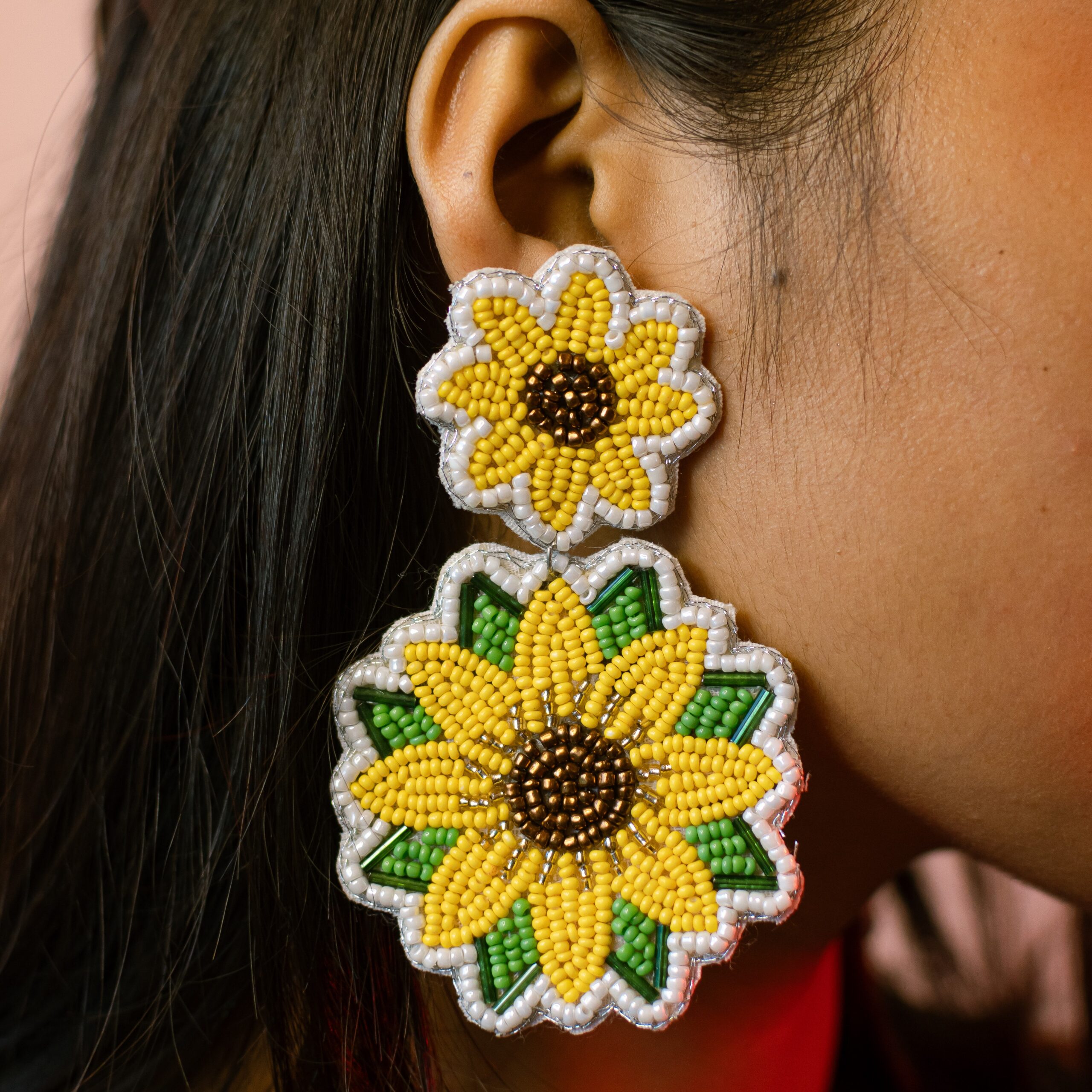 Macro close-up of two-tiered sunflower beaded earrings showing detailed seed bead work.