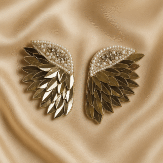 Masaira Celestial Wings earrings displayed on champagne satin fabric background