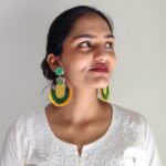 Close-up of Indian woman wearing Masaira's yellow-green pineapple beaded earrings with white kurta.