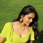 Woman wearing handmade parrot earrings in outdoor sunlight