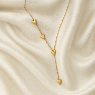 18 carat gold plated necklace with cascading heart motifs on a satin background