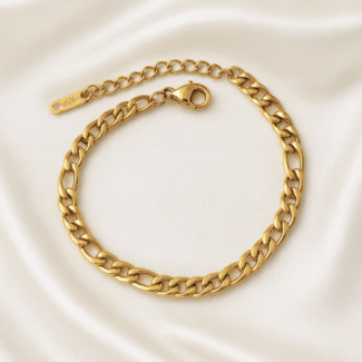 Gold Cuban link chain bracelet with adjustable clasp on ivory satin background