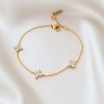 Elegant 18 carat gold plated bracelet with three cubic zirconia floral motifs on satin background