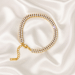 18 carat gold-plated double-row tennis bracelet with cubic zirconia stones on ivory satin background