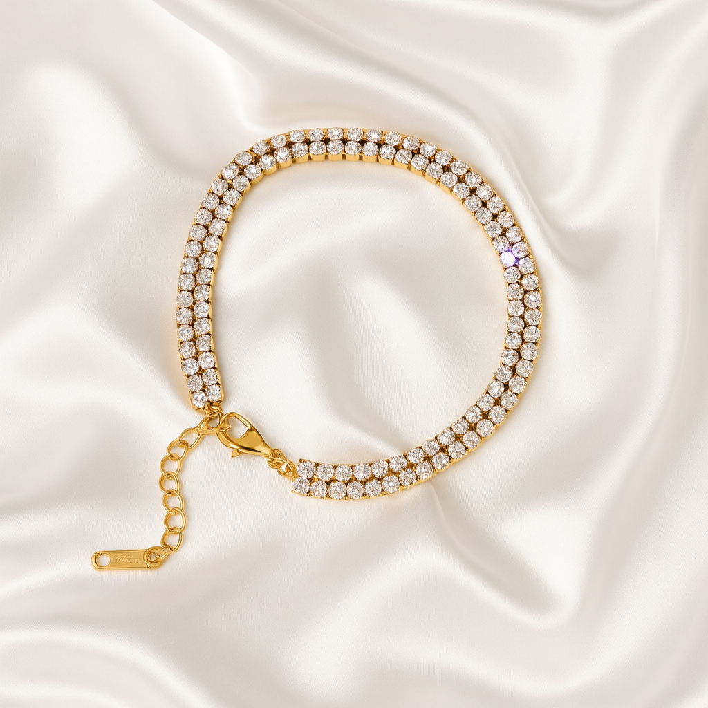 18 carat gold-plated double-row tennis bracelet with cubic zirconia stones on ivory satin background