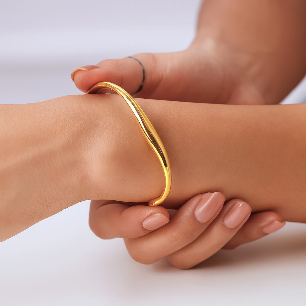Elara Sculpt Bangle in 18 Carat Gold – Hypoallergenic & Anti-Tarnish | Masaira Model wearing a sculptural open bangle in 18 carat gold from Masaira, styled with nude nails