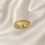 Gold open ring with teardrop-shaped ends placed on ivory satin background
