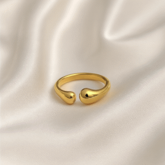 Gold open ring with teardrop-shaped ends placed on ivory satin background