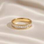Gold band ring with a row of square-cut clear stones set in the center