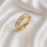 Gold eternity band with marquise-cut zirconia stones placed on ivory satin fabric