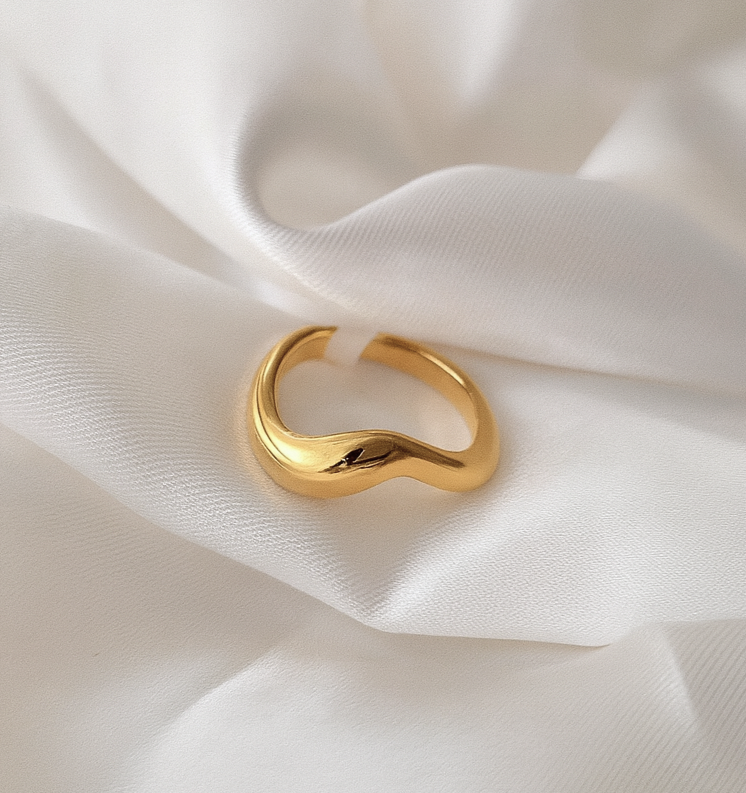 Solstice Band 18 Carat Gold Sculptural Ring – Masaira Gold sculptural wave ring placed on ivory satin fabric