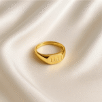 Gold signet ring engraved with the number 1111 placed on plain white background