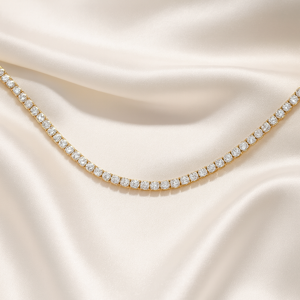 Gold-plated tennis necklace with simulated diamonds on ivory satin background