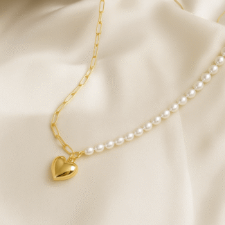 18 carat gold plated heart and pearl link necklace on ivory satin fabric