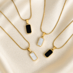 Reversible gold pendant necklace with black and white enamel on satin background