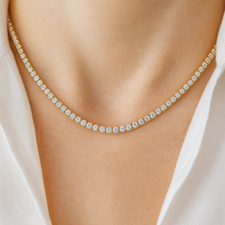 Model wearing 18 carat gold-plated tennis necklace with simulated diamonds