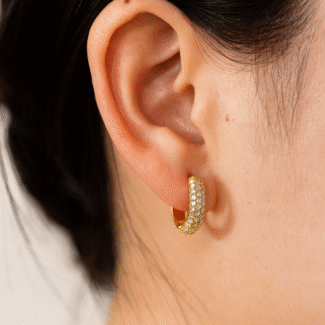 Create a hyper-realistic, high-resolution, high-definition product image using the attached photograph of the jewelry piece exactly as it is — without altering the design, shape, size, or any intricate details. Replace the current background with a luxurious ivory white satin silk fabric that features soft folds, natural highlights, and realistic shadows to enhance the premium aesthetic. The jewelry should appear naturally placed or subtly floating on the satin surface, as seen in a professional studio shoot. Make sure the yellow colour of the gold is not very cheap yellow colour but is very subtle and luxurious yellow colour. Include a soft, natural shadow or subtle reflection beneath the product to add depth and realism. Ensure the final image is in a clean 1:1 square aspect ratio — ideal for high-end e-commerce or website display. looking for very very clear image