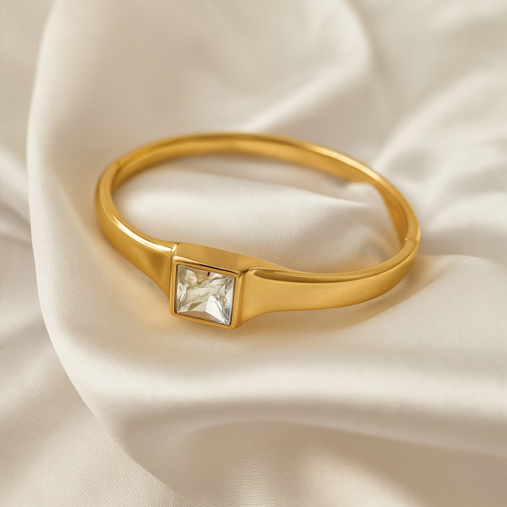 Crystal Crest Bangle – 18 Carat Gold Plated Hypoallergenic Jewelry for Women Elegant gold bangle with square-cut stone at center, made with 18 carat gold plating