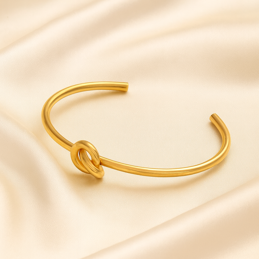 18 carat gold plated open cuff bracelet with central knot design