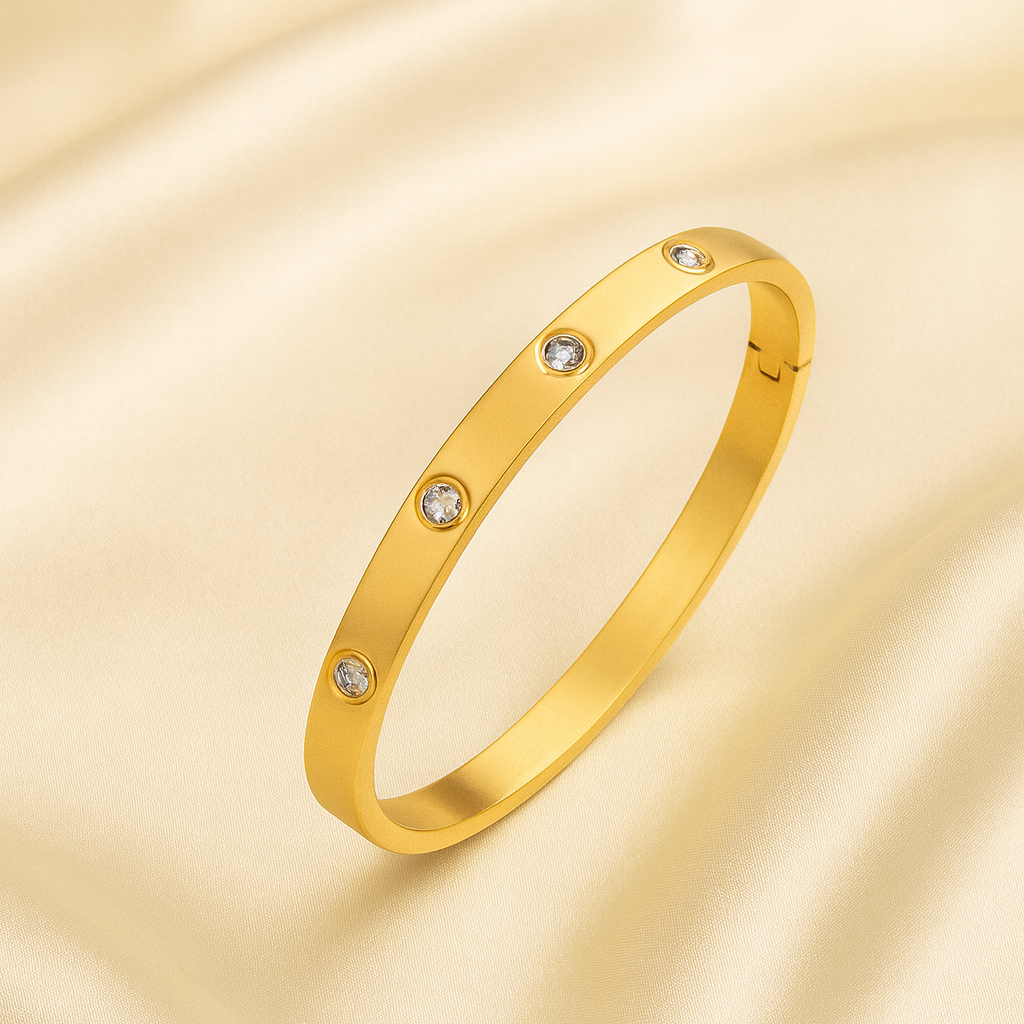 18 carat gold plated bangle with embedded cubic zirconia stones and hinged closure