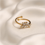 Open gold ring with a cluster of marquise-cut clear stones on white background