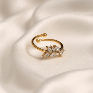 Open gold ring with a cluster of marquise-cut clear stones on white background