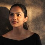 Model wearing gold wave earrings in minimalist drop style with elegant evening outfit