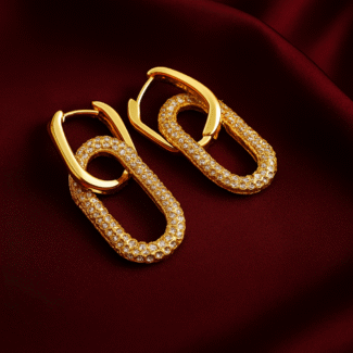 Masaira Lustre Link gold-plated rectangular huggie earrings with pavé zirconia chain links on deep maroon satin