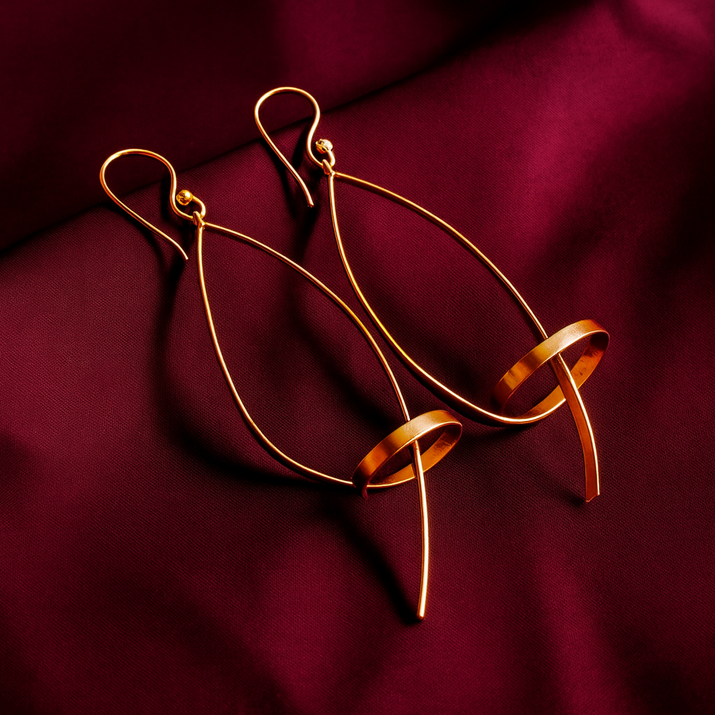 Unique geometric loop drop gold plated earrings with circular accents on maroon satin fabric