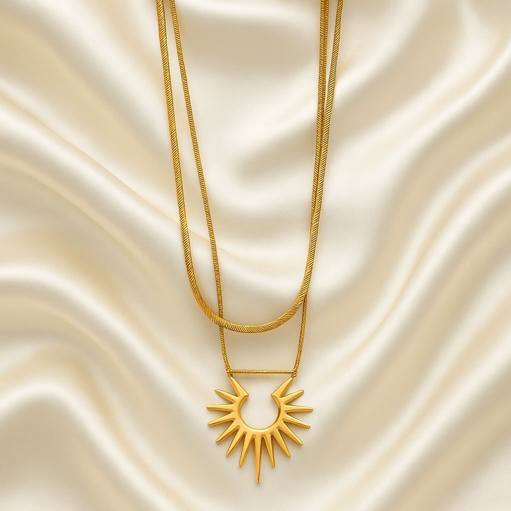 Solar Radiance Necklace | 18 Carat Gold Plated | Hypoallergenic 18 carat gold plated double-layer necklace with sunburst pendant on satin background