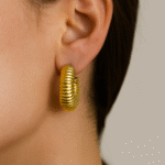 Radiant Ripple Hoops in 18 carat gold with ridged sculptural texture on model