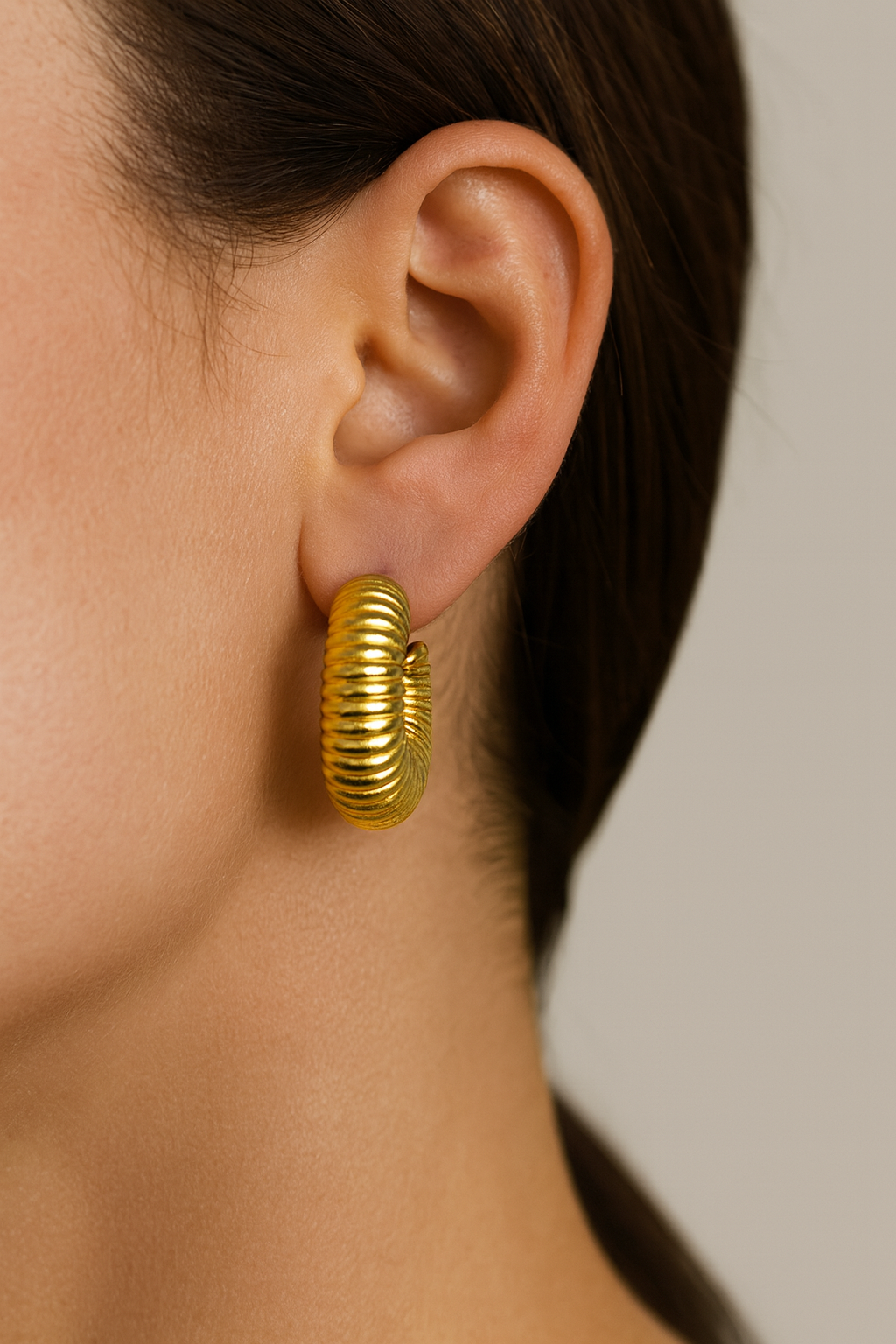 Radiant Ripple Hoops in 18 carat gold with ridged sculptural texture on model